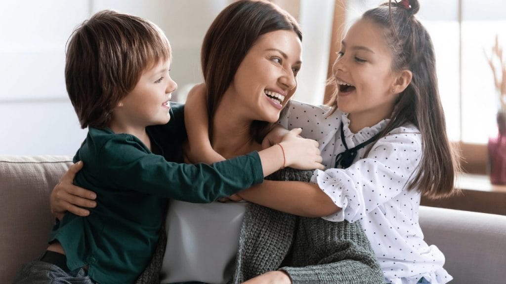 Mother hugs daughter and son