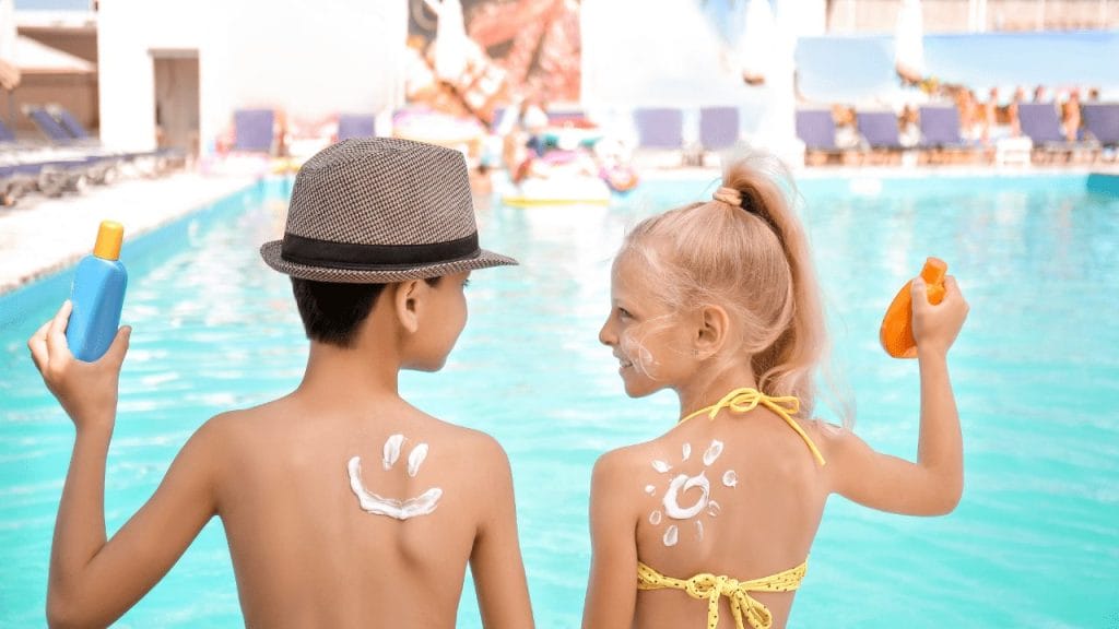 Kids apply sunscreen at the pool